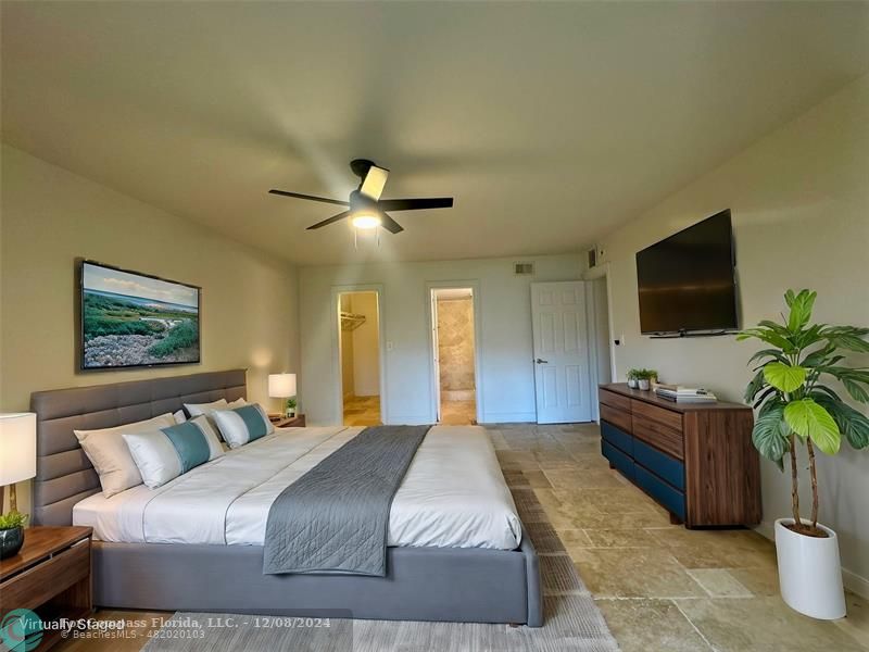 a bedroom with a bed and a flat screen tv