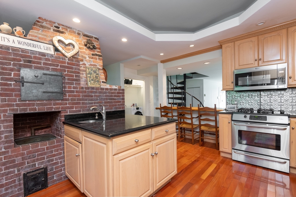 a kitchen with stainless steel appliances kitchen island granite countertop a stove a sink and a microwave