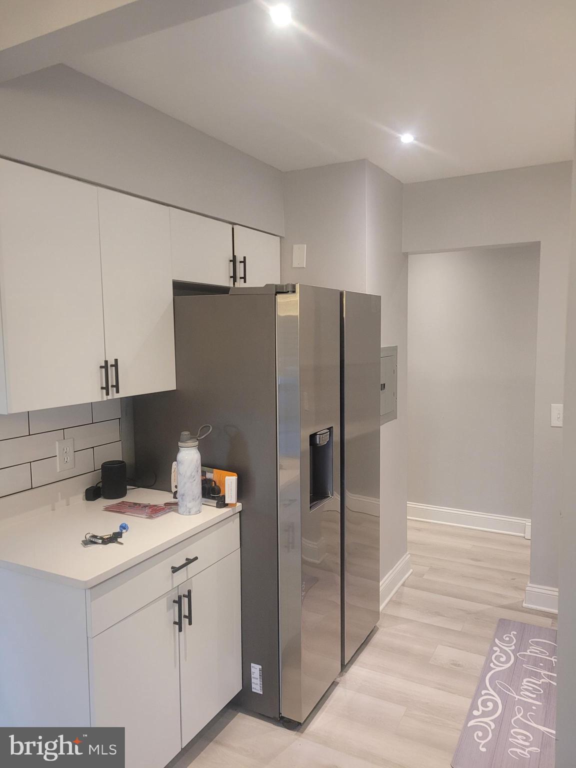 a kitchen with a sink a refrigerator and cabinets