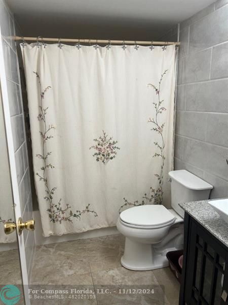 a bathroom with a toilet and a shower curtain