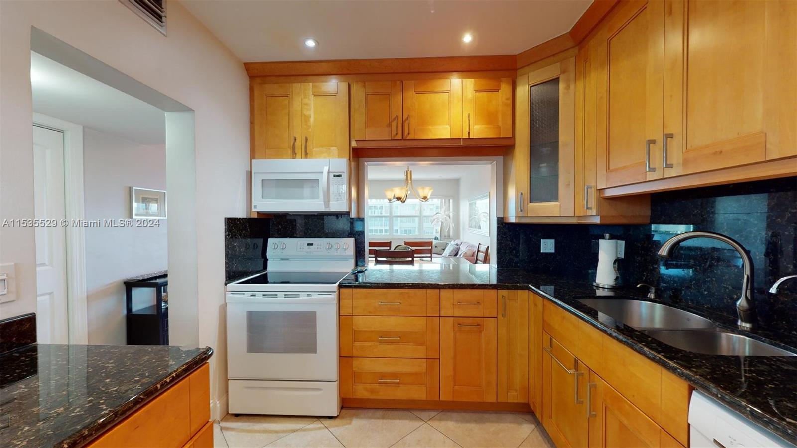 a kitchen with granite countertop a sink a stove and cabinets