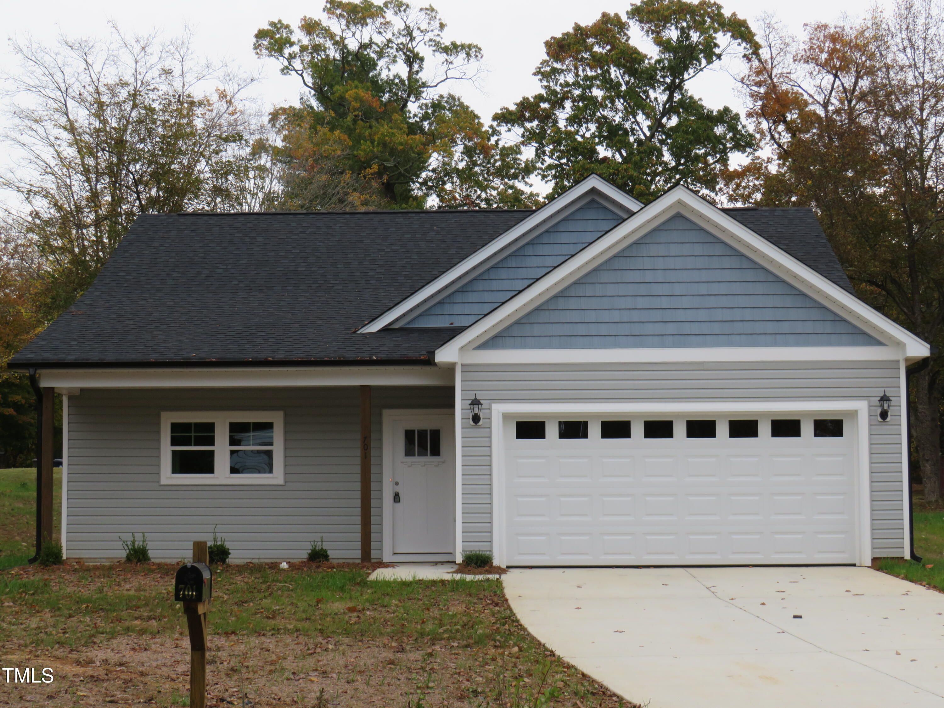 a view of house with a yard and large tree