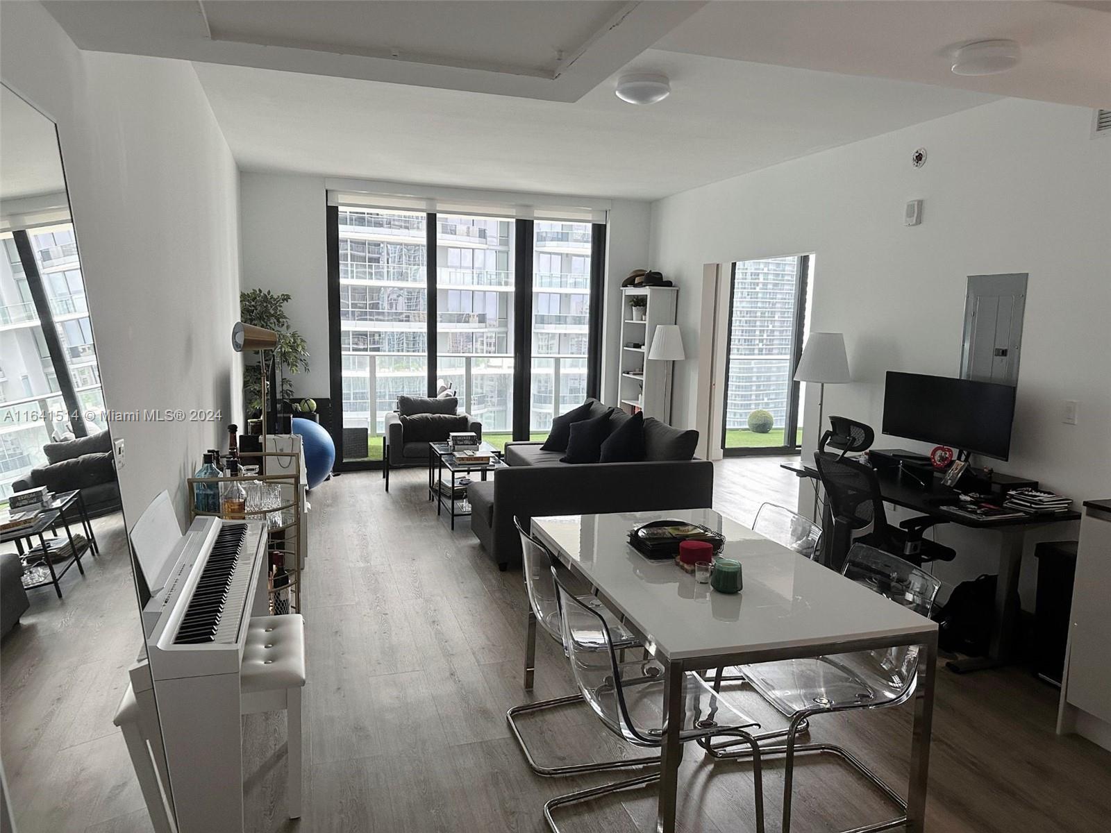 a living room with furniture a flat screen tv and a large window