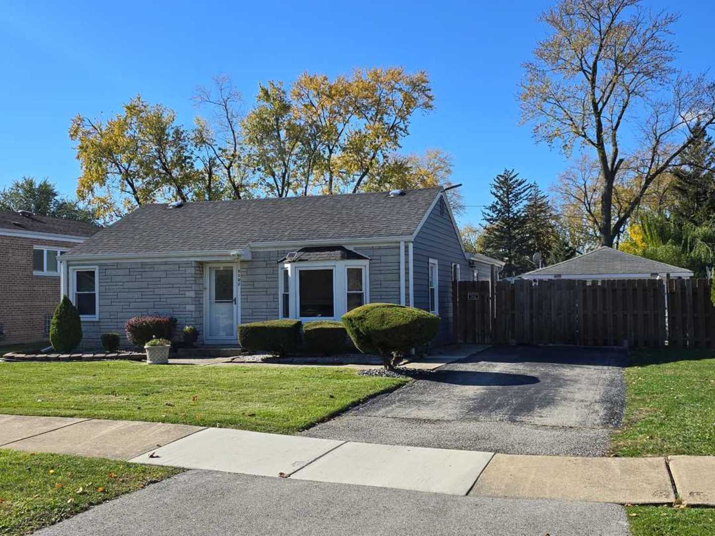 a front view of a house with a yard and trees