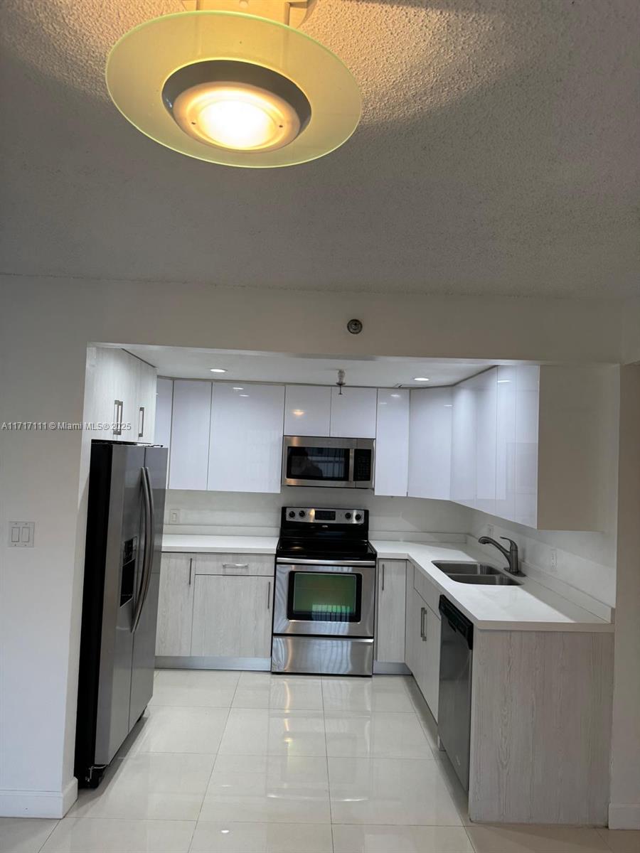 a kitchen with a stove a refrigerator and a sink