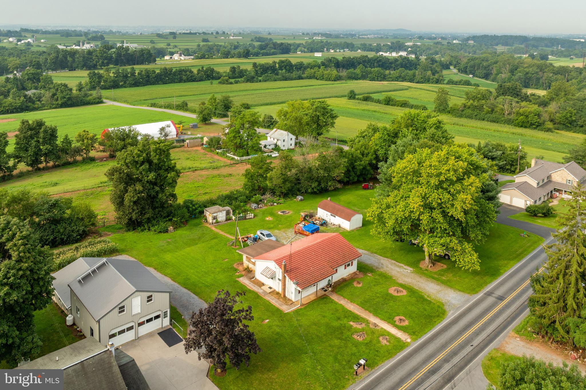 an aerial view of a house with a garden and lake view