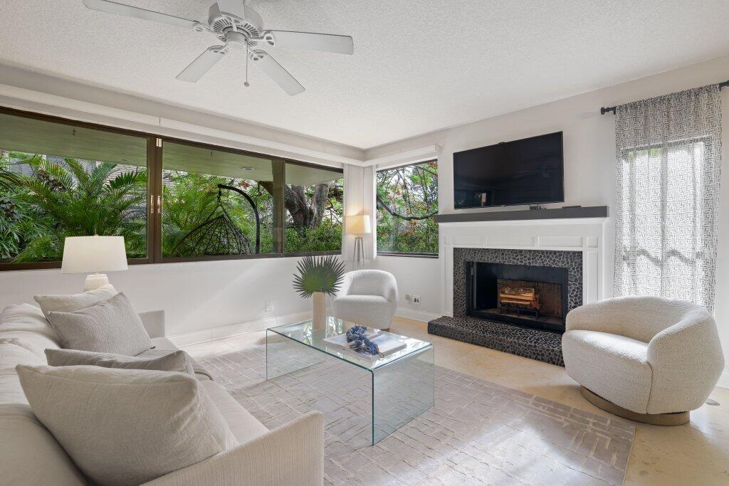 a living room with furniture a large window and a fireplace