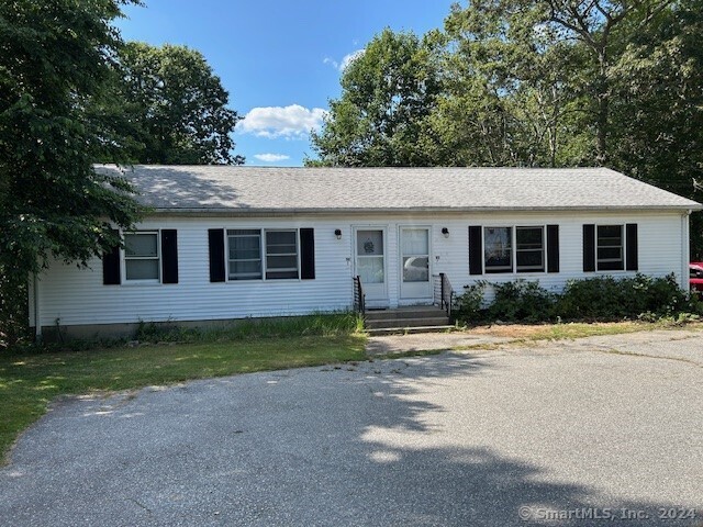 a front view of a house with a garden and yard