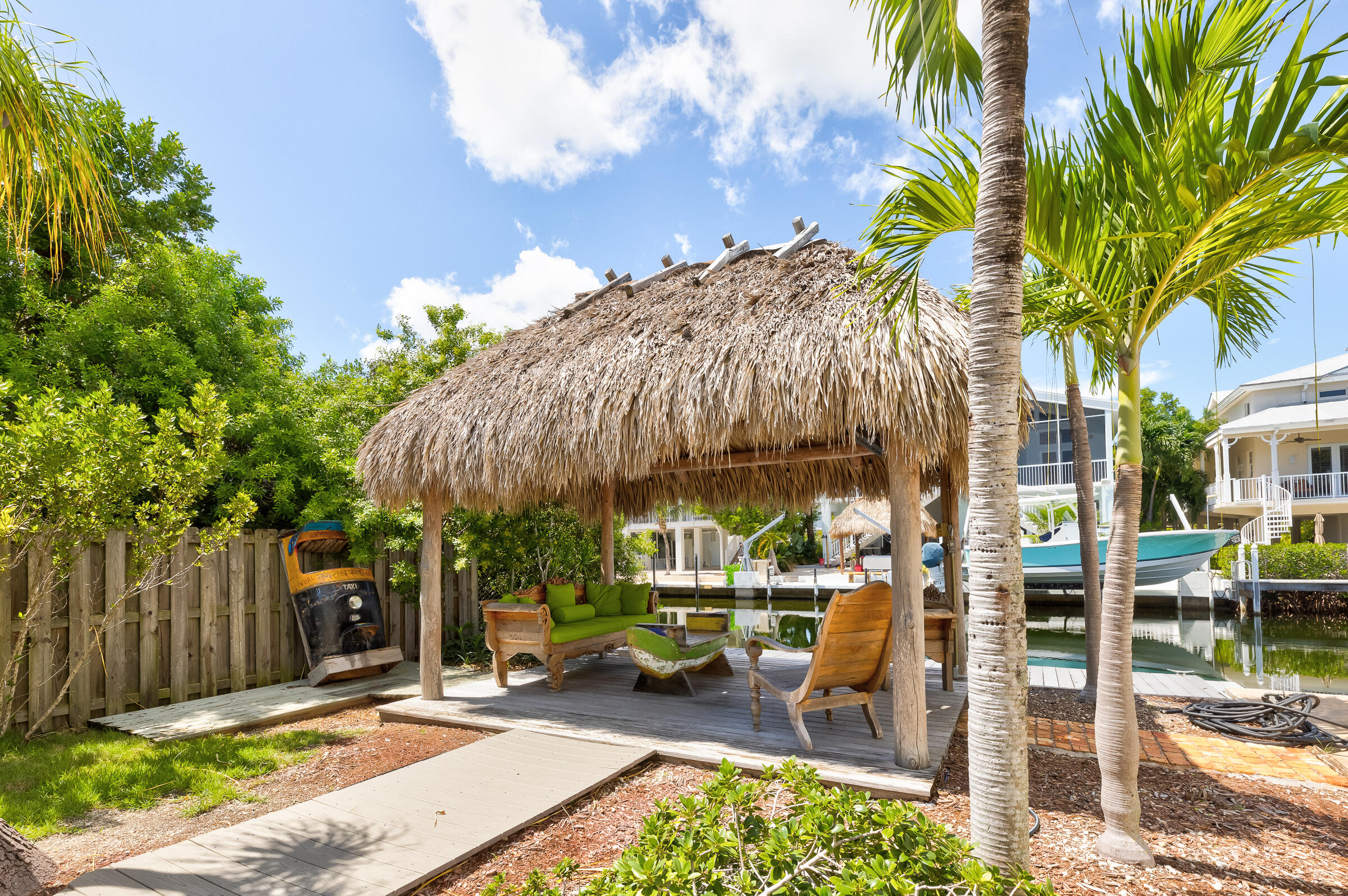 a view of a patio with a table and chairs under an umbrella with wooden fence