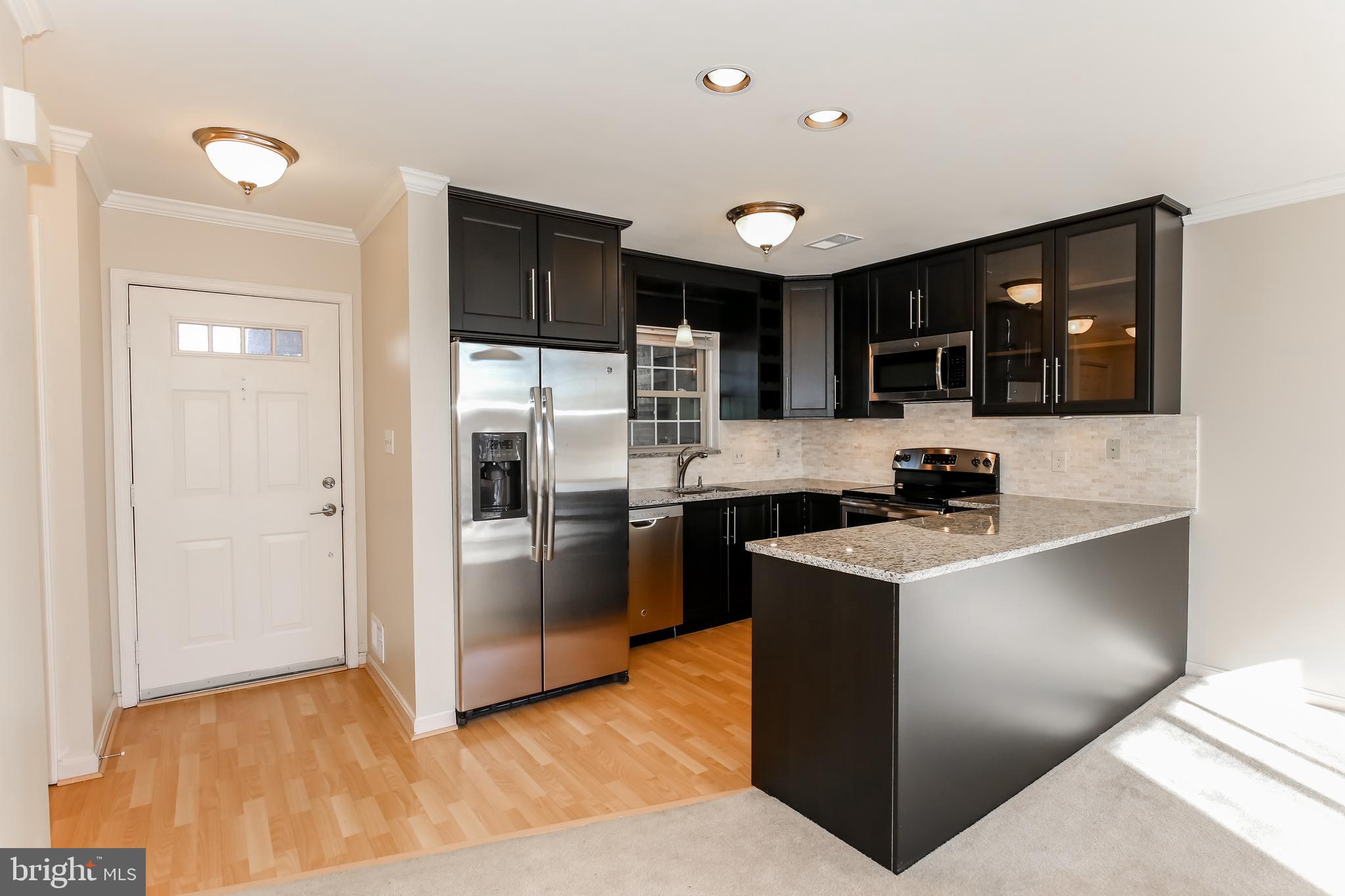 a kitchen with stainless steel appliances granite countertop a refrigerator and a stove top oven