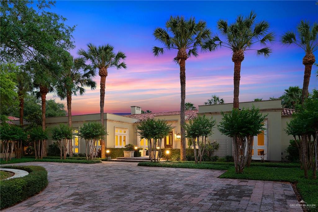 a palm tree sitting in front of a house with a big yard