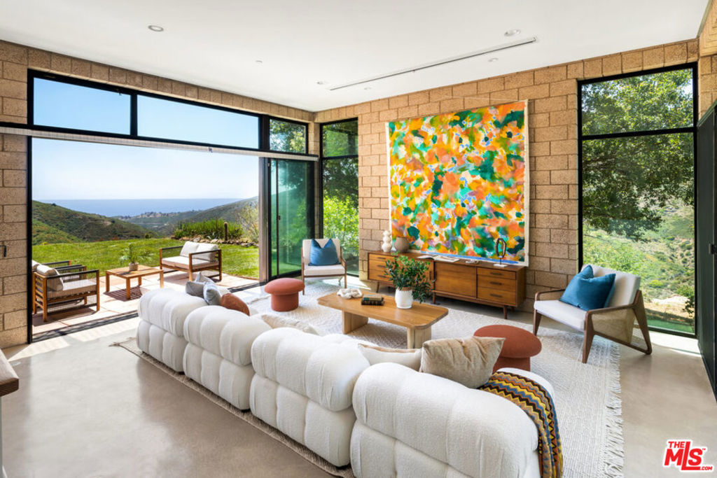 a living room with fireplace furniture and a large window