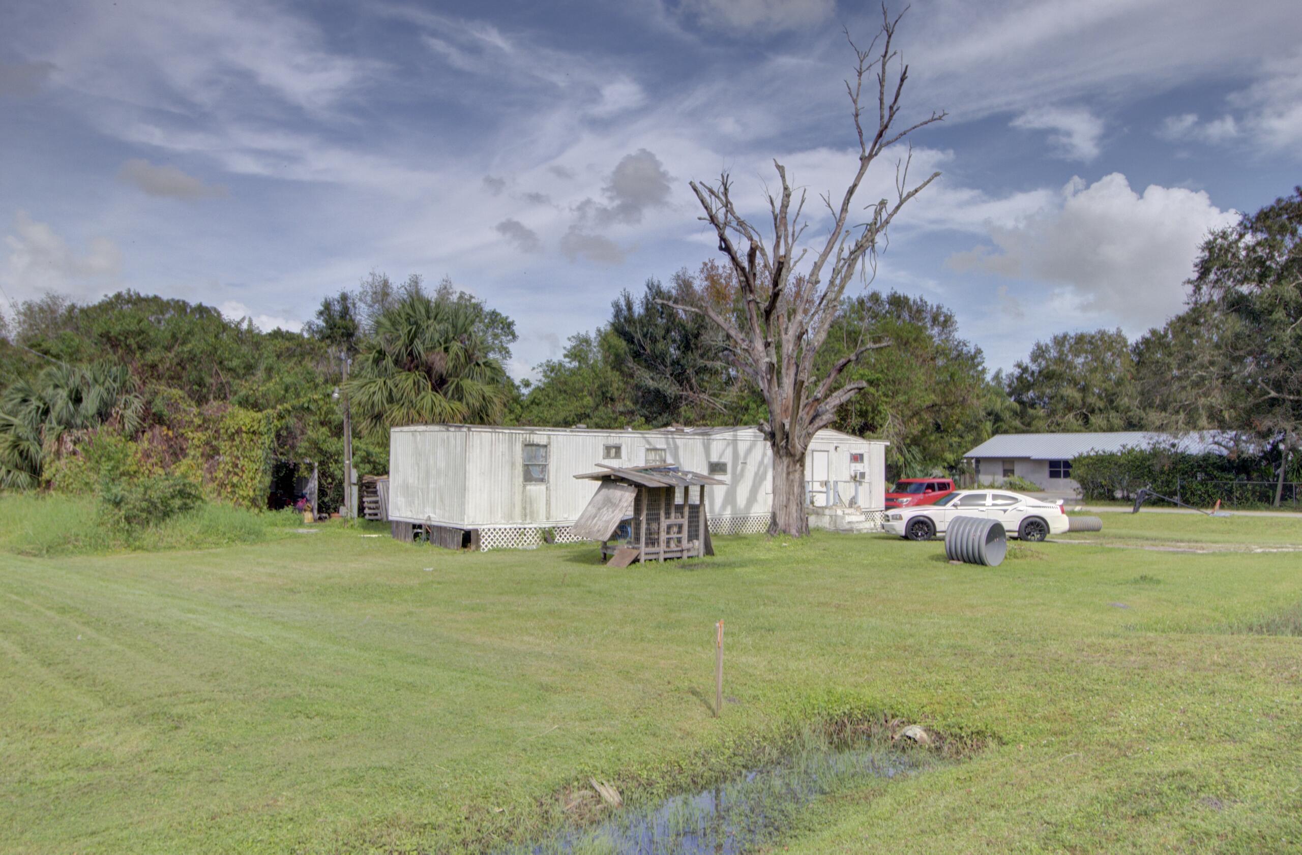 a white house with a big yard and large trees