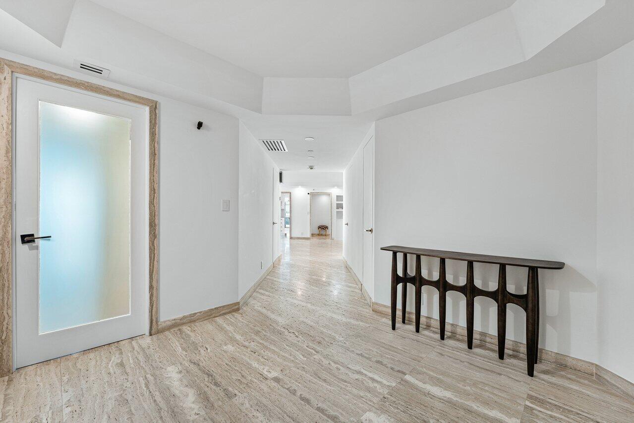 a view of a hallway with wooden floor and a bathroom