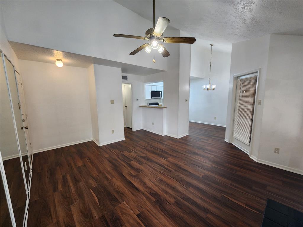 a view of a room with wooden floor and a ceiling fan