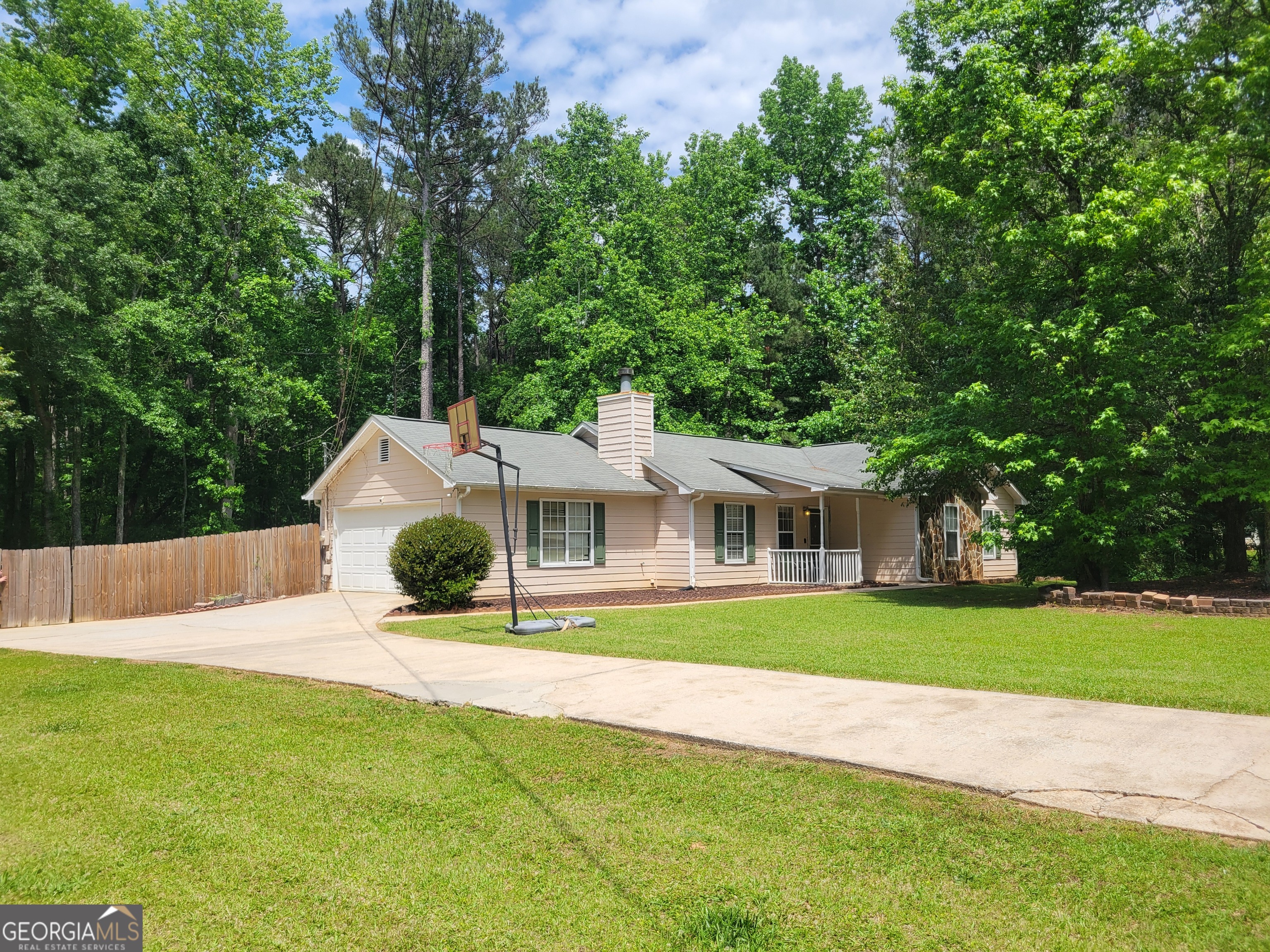 a view of a house with a yard and large trees