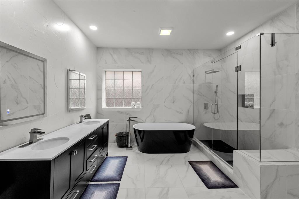 a bathroom with a double vanity sink toilet mirror and bathtub