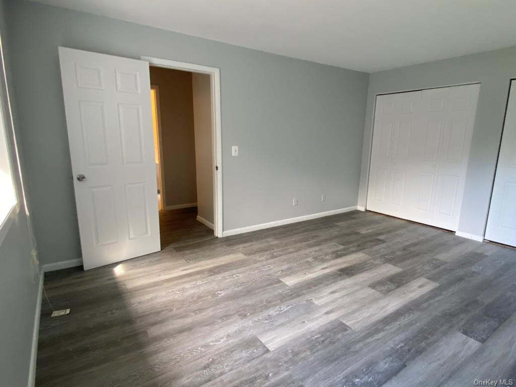 an empty room with wooden floor and closet