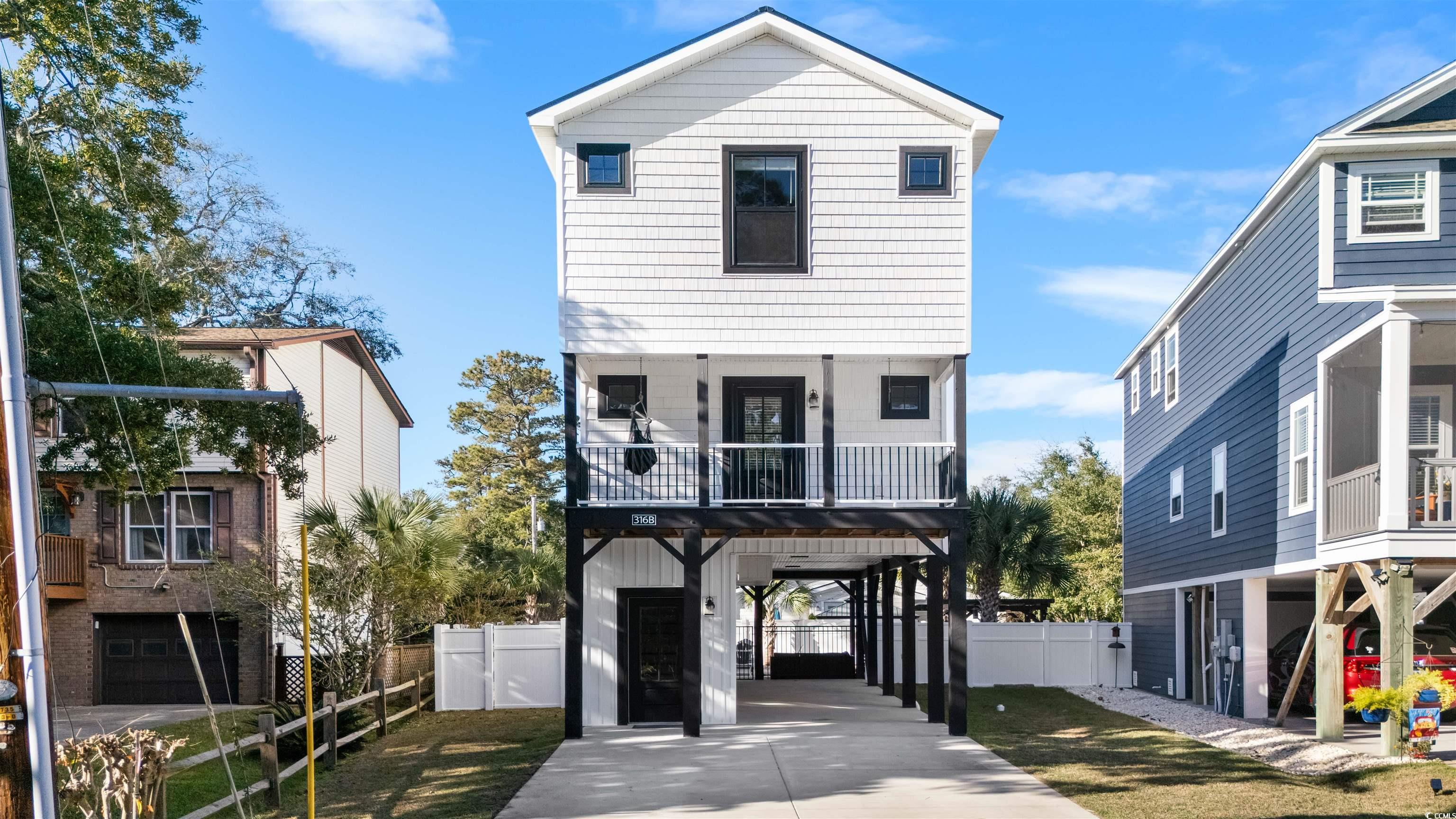 View of front of property with a carport and a bal