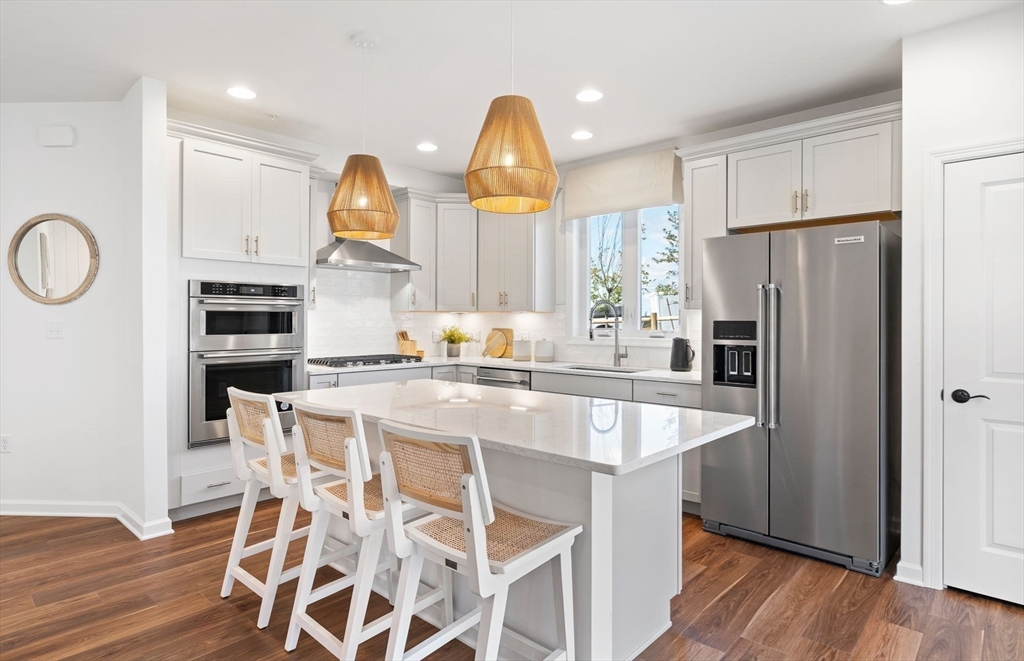 a kitchen with stainless steel appliances granite countertop a sink a stove and a refrigerator