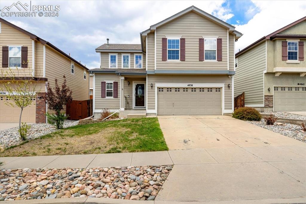 a front view of a house with a yard and garage