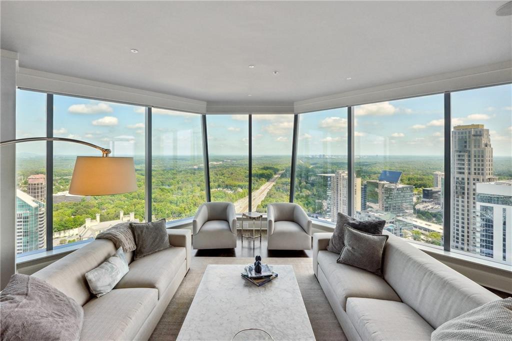 a living room with furniture and floor to ceiling windows