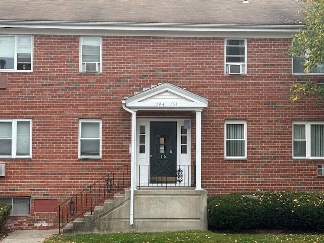 a view of brick house with large windows and a yard