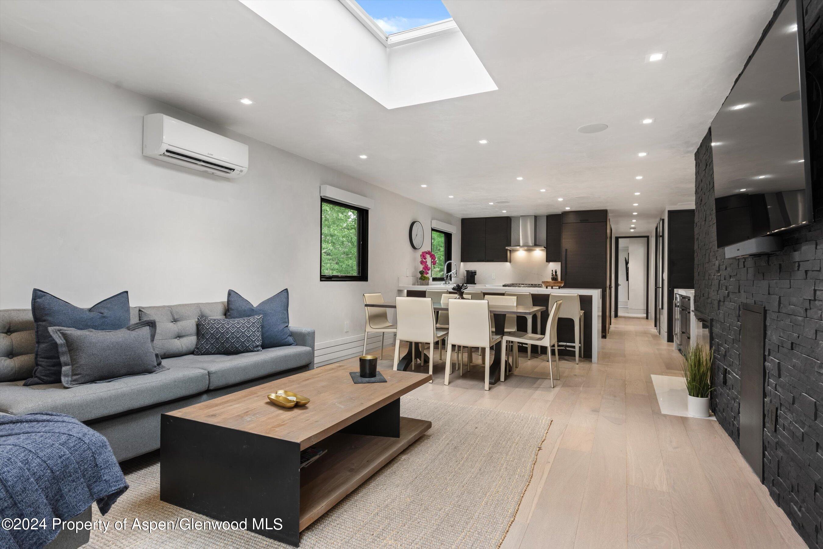 a living room with furniture and a dining table with kitchen view