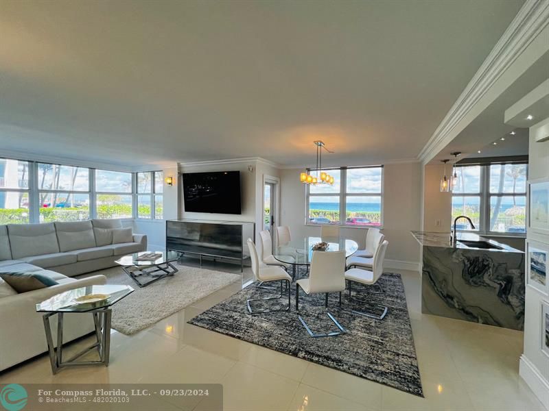 a living room with furniture a flat screen tv and a large window