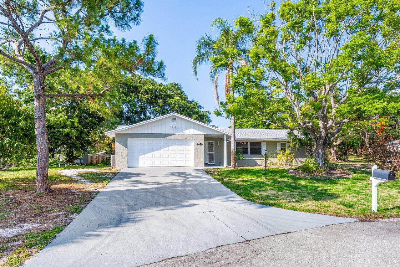 a front view of a house with a yard and trees