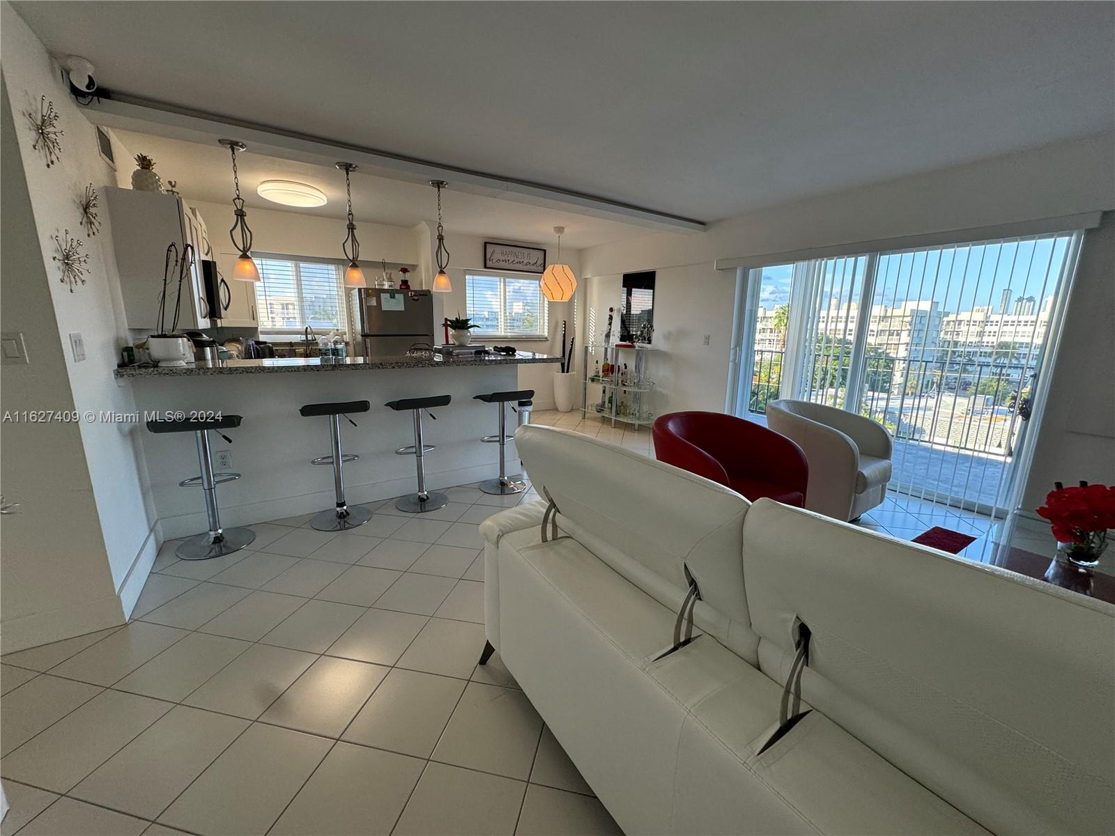 a room with stainless steel appliances kitchen island granite countertop furniture and a view of living room