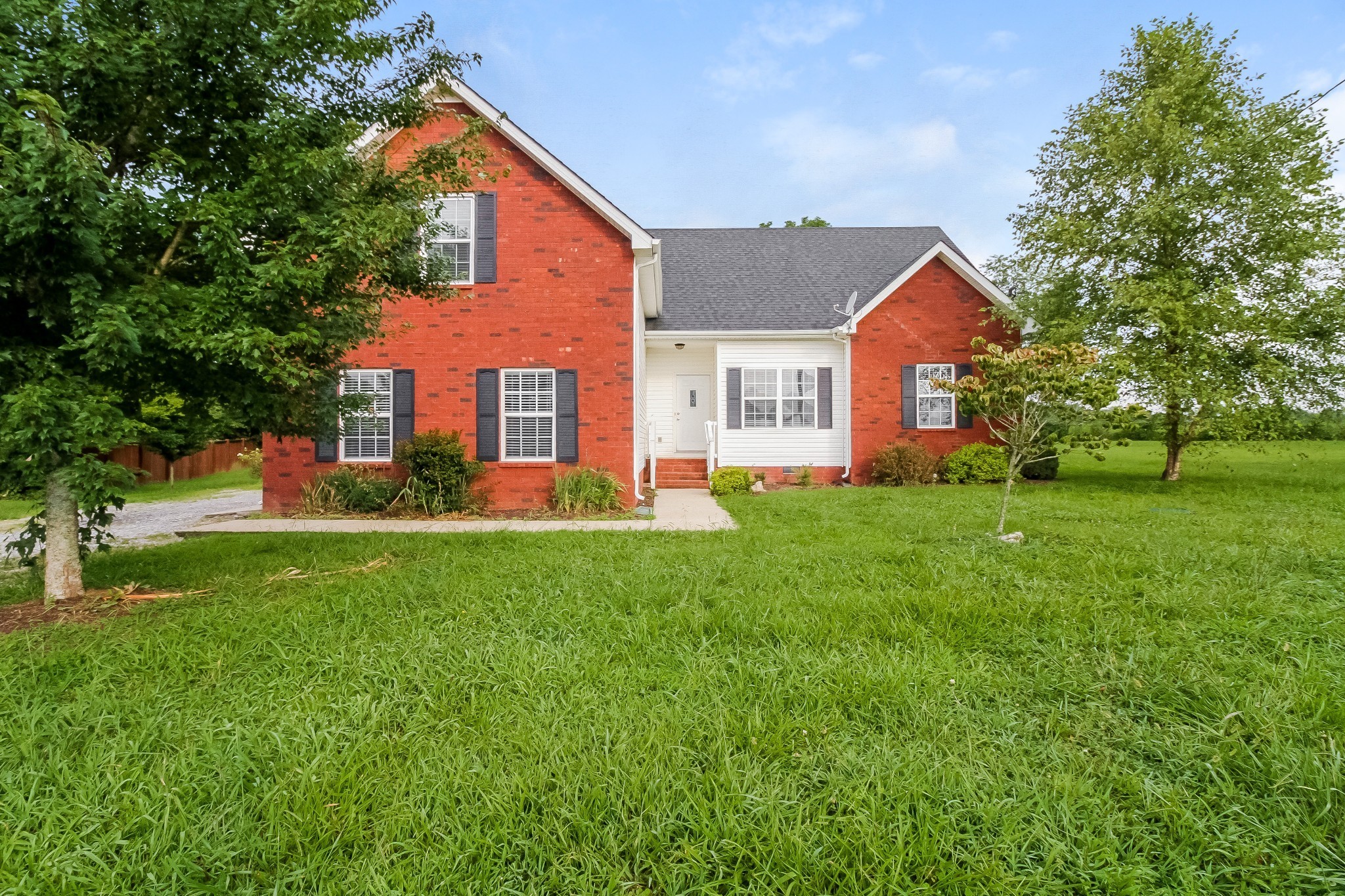 a front view of house with yard and green space