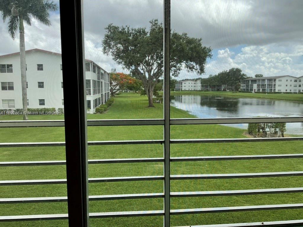 a view of a lake from a balcony with floor to ceiling windows