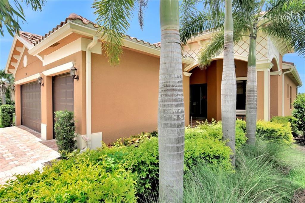 a view of a house with a small yard plants and palm trees