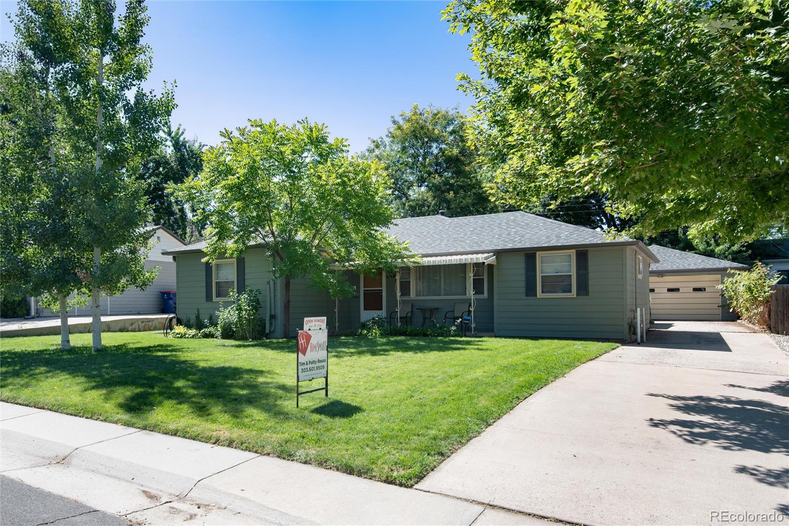 a front view of a house with a yard and trees