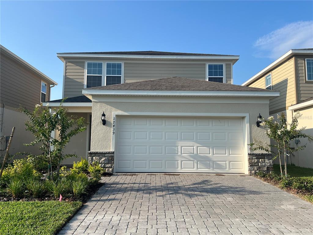 a front view of a house with a yard and a garage