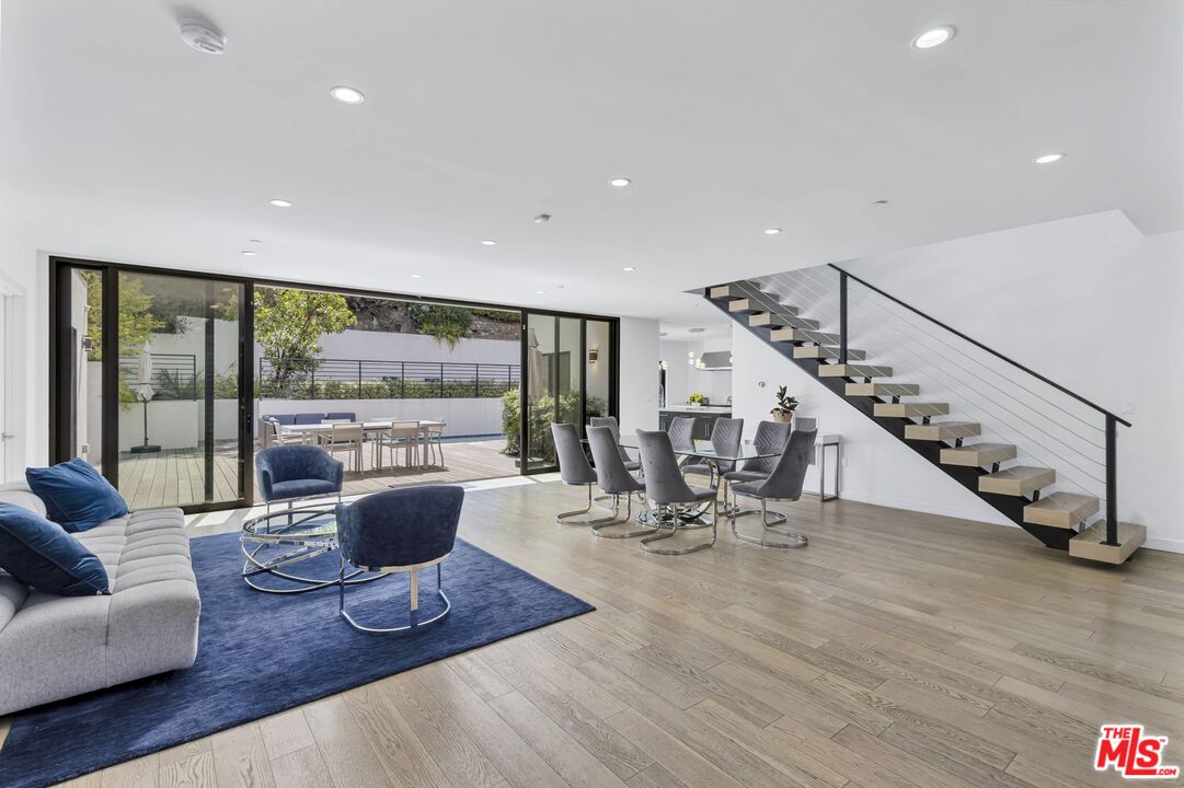 a living room with furniture floor to ceiling window and stairs