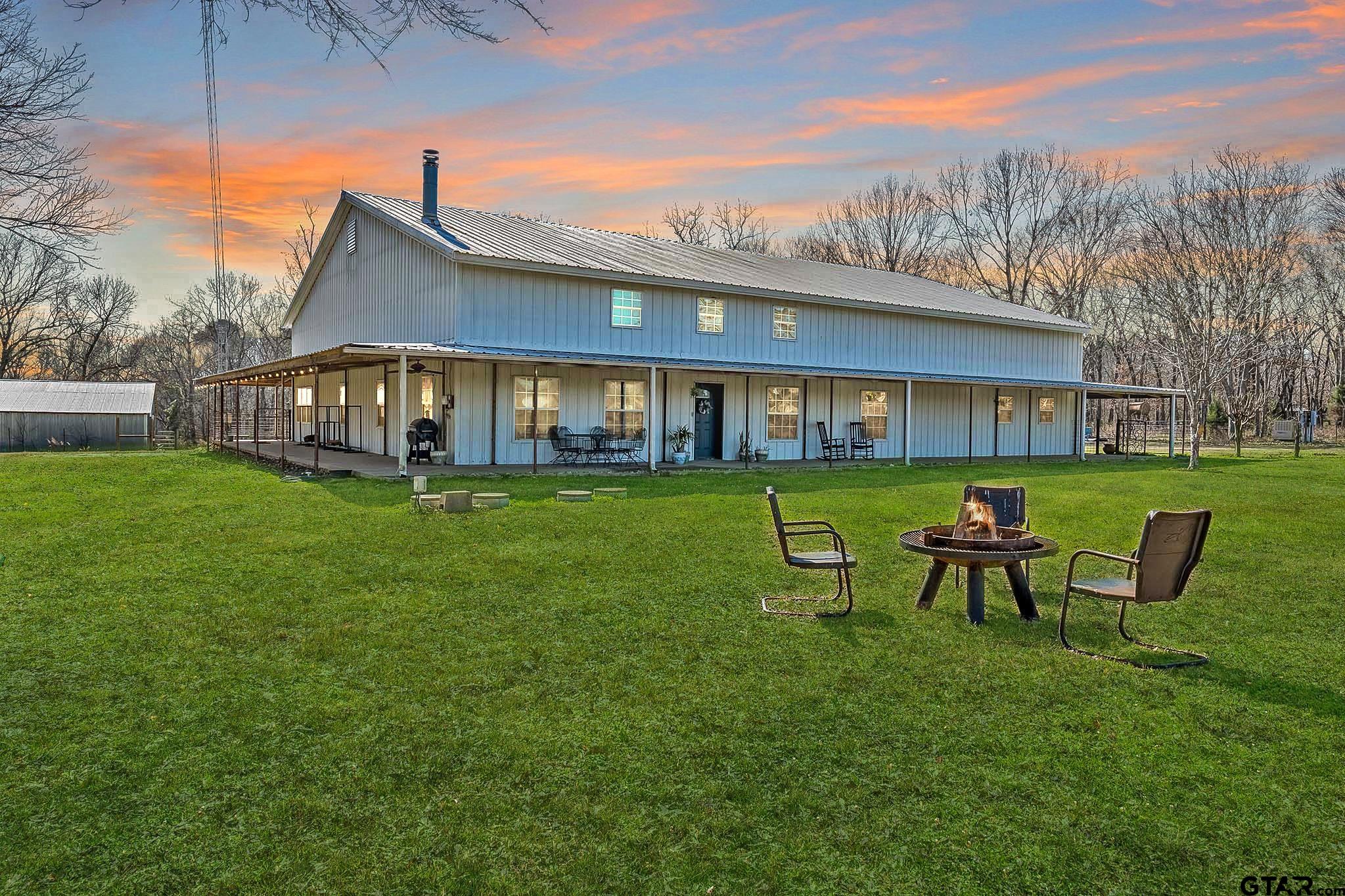 a view of a house with a yard deck and chairs