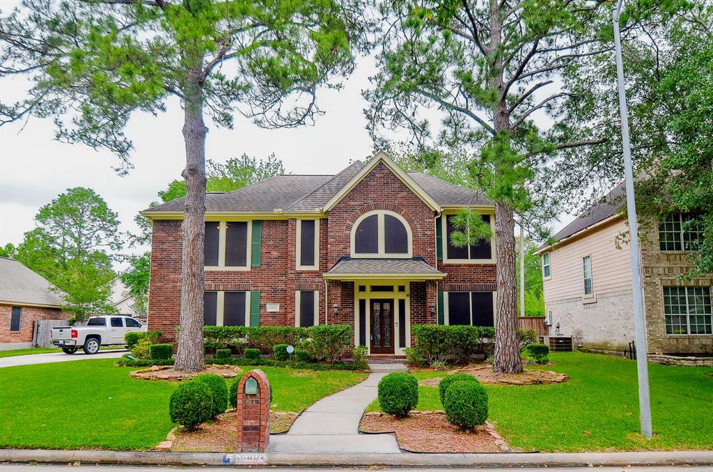 a front view of a residential houses with yard and green space