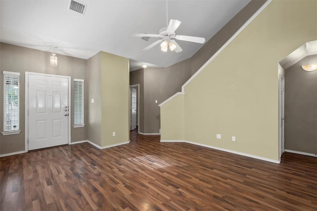 a view of an empty room with wooden floor