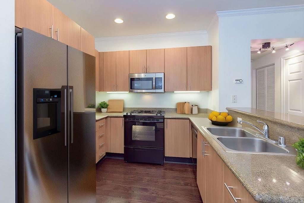 a kitchen with granite countertop a refrigerator stove and sink