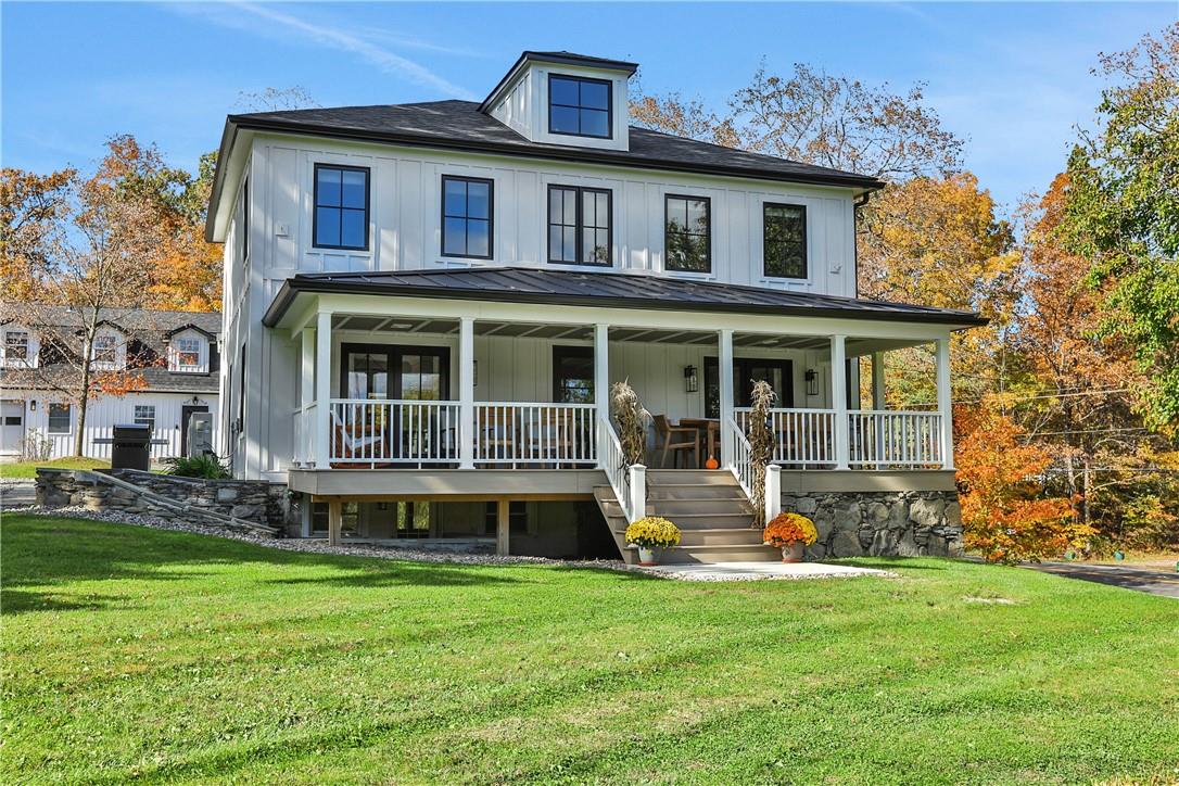 View of front of house featuring covered porch and a front yard