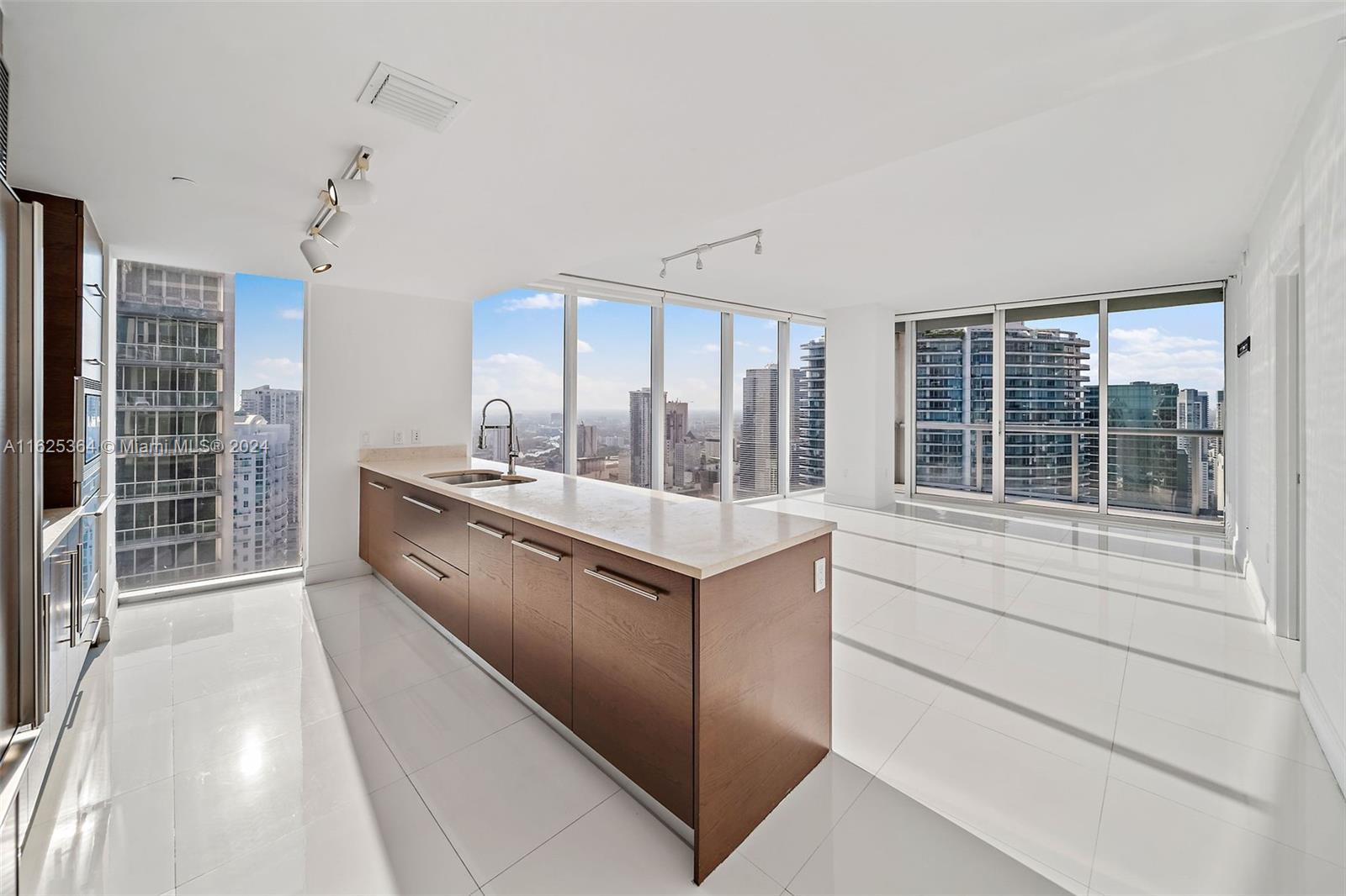 a kitchen with stainless steel appliances granite countertop a stove and a large window