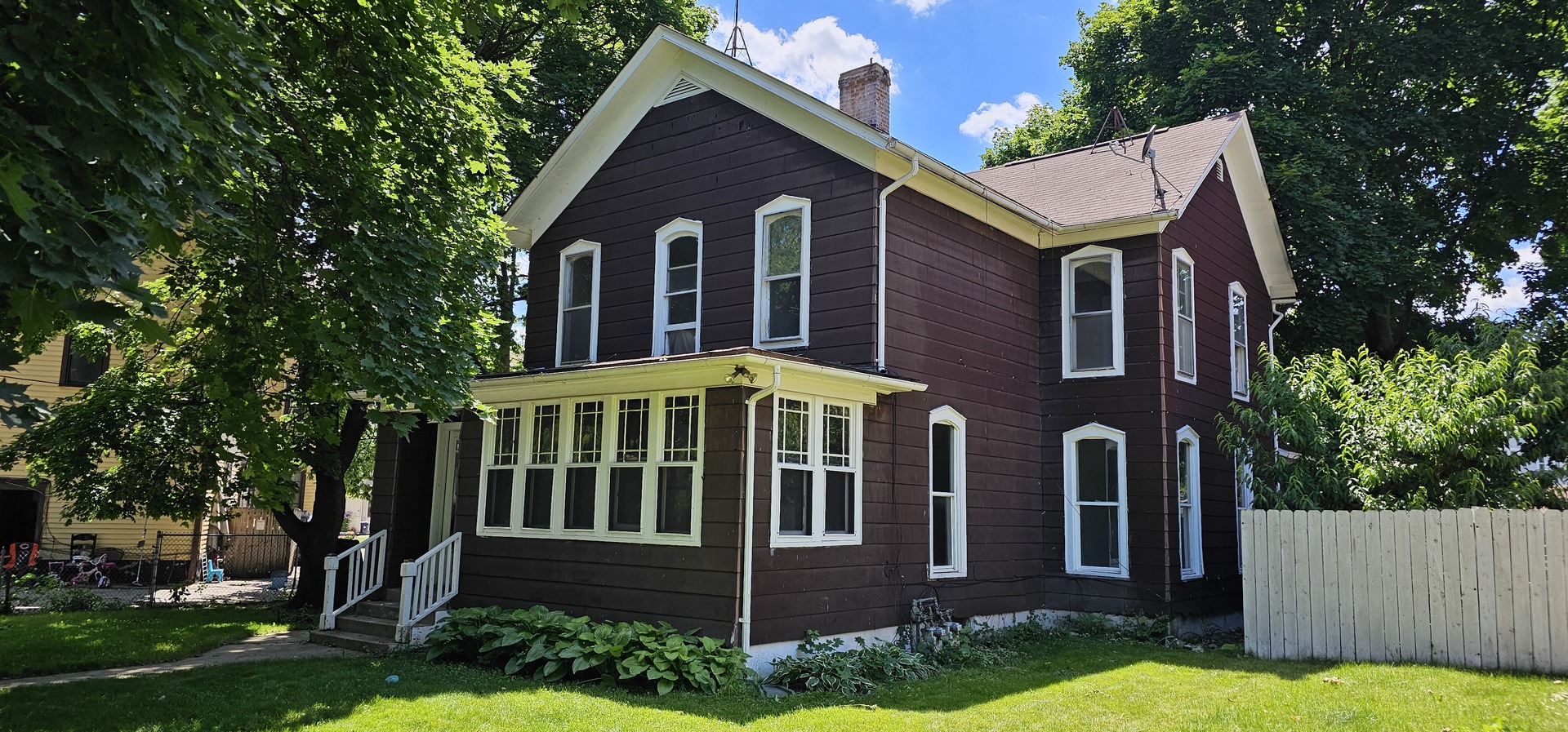 a front view of a house with yard and green space