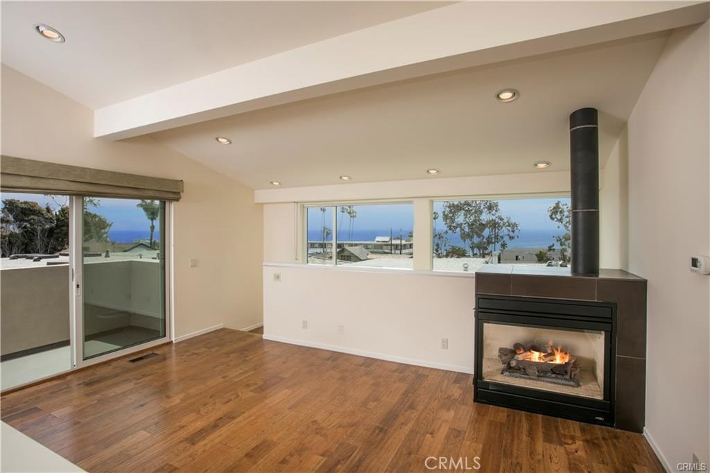 a living room with wooden floor and a fireplace