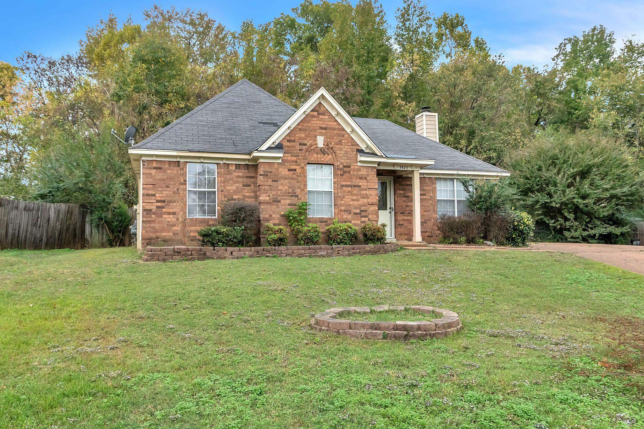 a front view of a house with a yard and trees