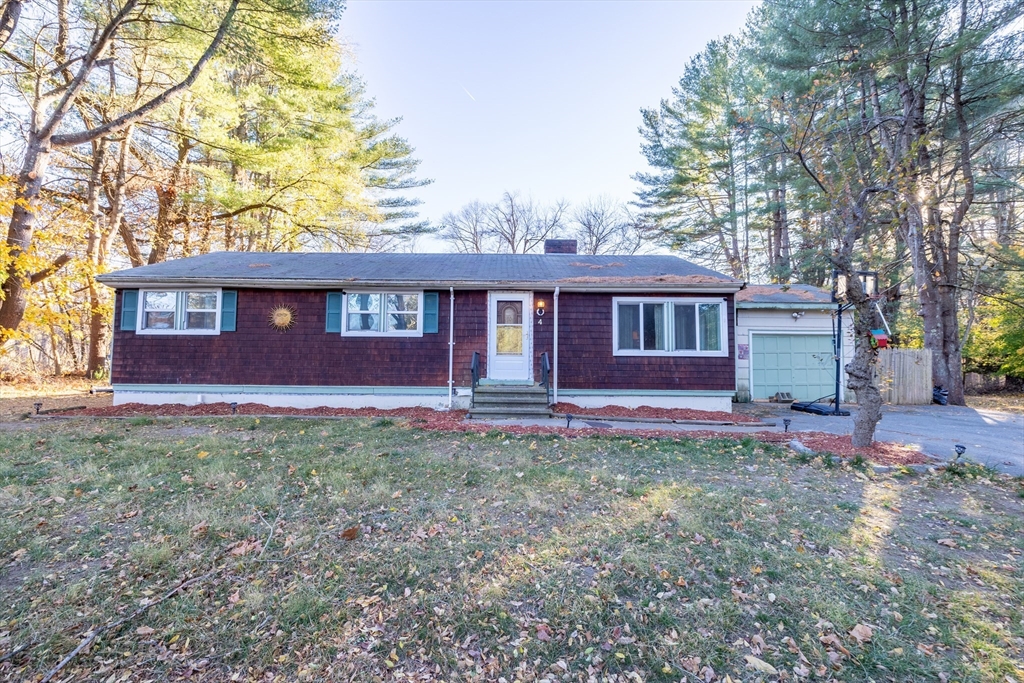 a front view of a house with yard and trees