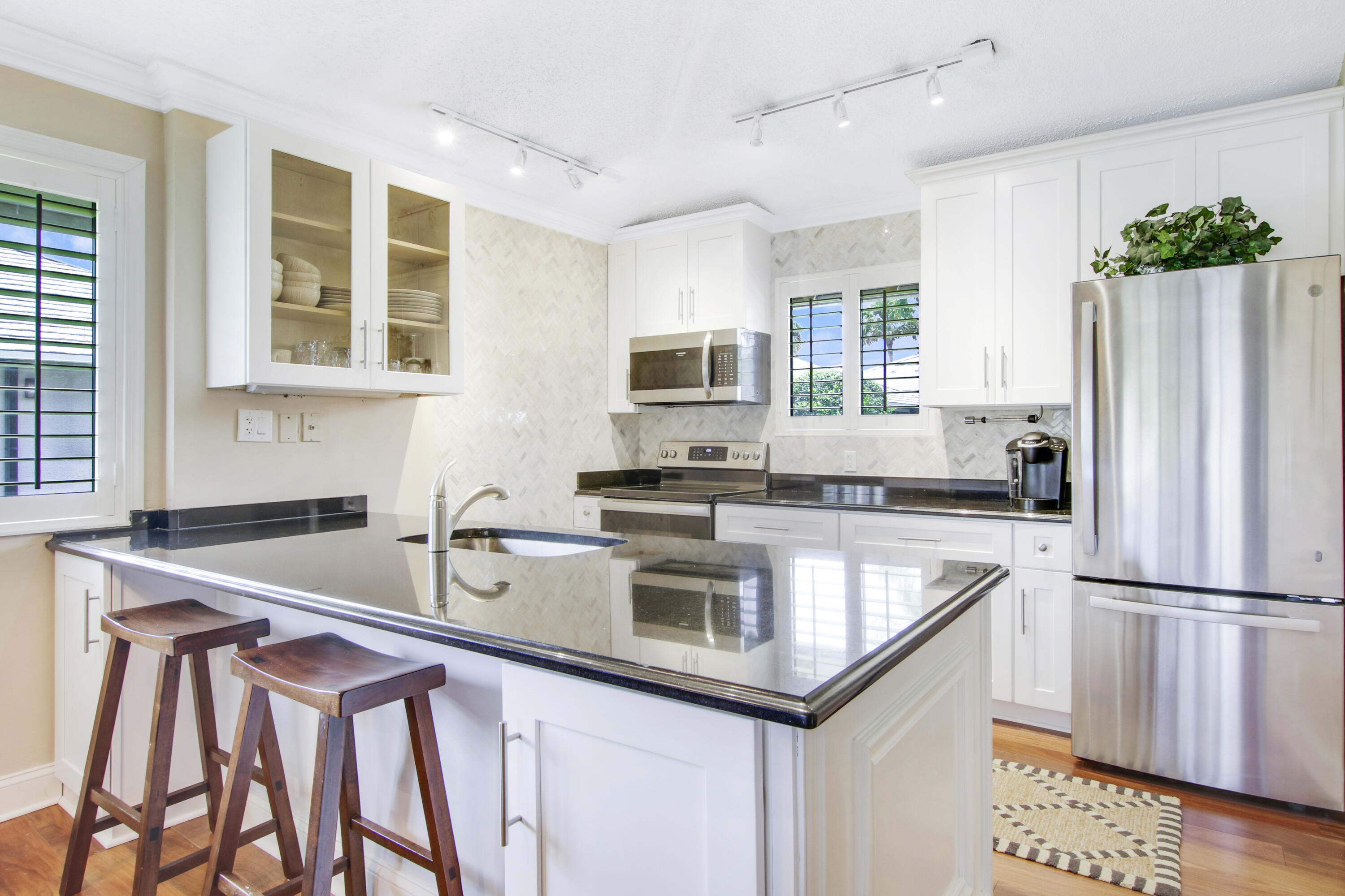 a kitchen that has a sink cabinets counter space and stainless steel appliances