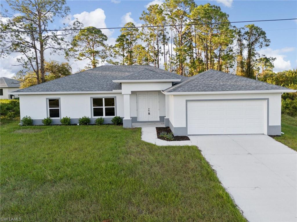 View of front of property featuring a front yard and a garage