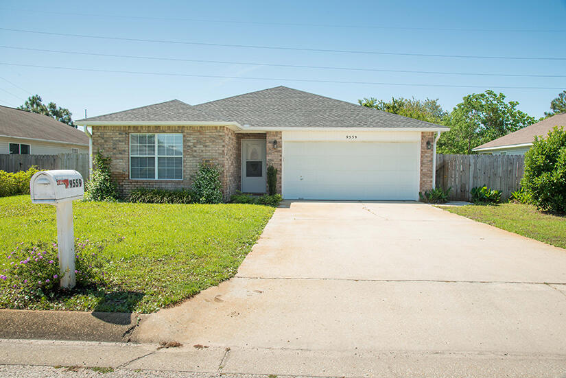 a front view of a house with yard and green space